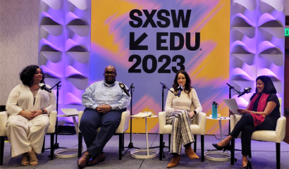 Four panelists sit in chairs on stage during a session at SXSW EDU 2023, where branded signage on the wall behind them is displayed.