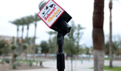 A microphone showing "National School Choice Week" stands on a school campus.
