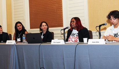 A panel of five speakers at a conference session.