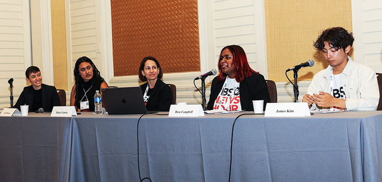 A panel of five speakers at a conference session.