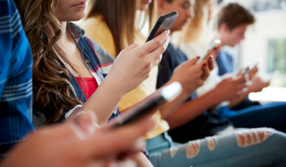 A group of students on their cell phones ignore each other.