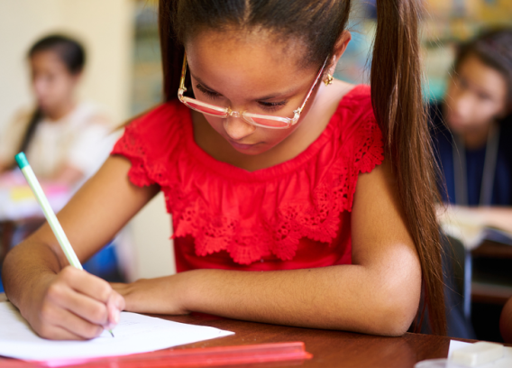 A few Hispanic students taking tests in school.