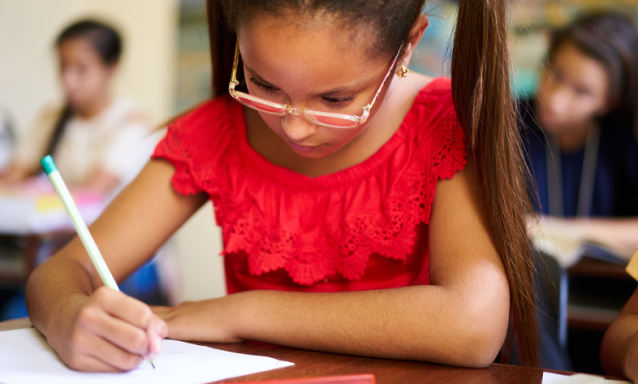 A few Hispanic students taking tests in school.