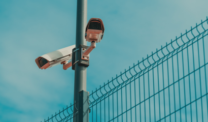 Two surveillance cameras mounted to a pole point in opposite directions.