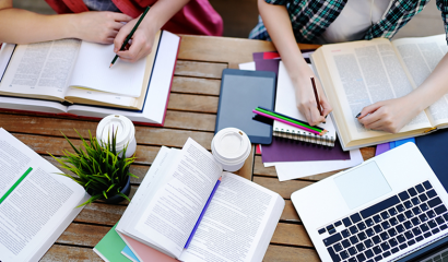 An overhead view of two students studying and reading books