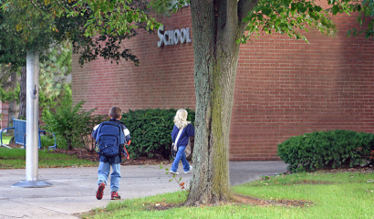 Children walking into a brick school building