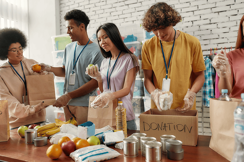 Young male and female volunteers pack food for donation.
