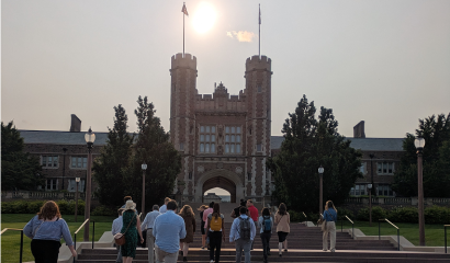 A group of people climb stairs on the campus of a university.