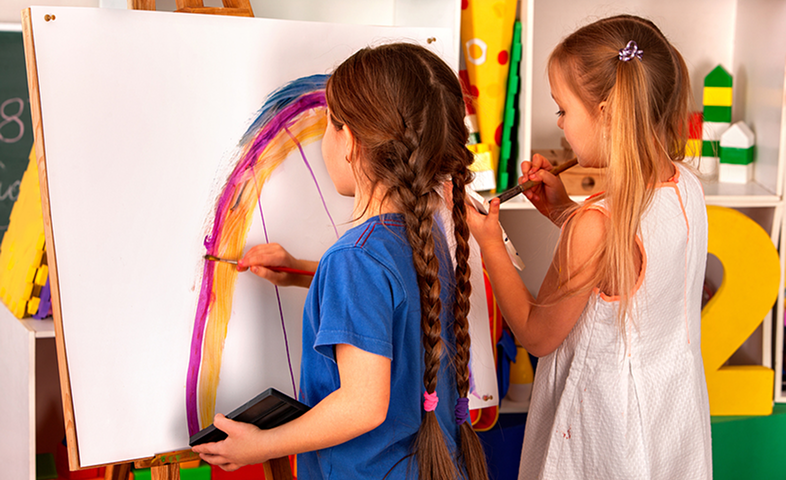 Children finger painting on an easel.