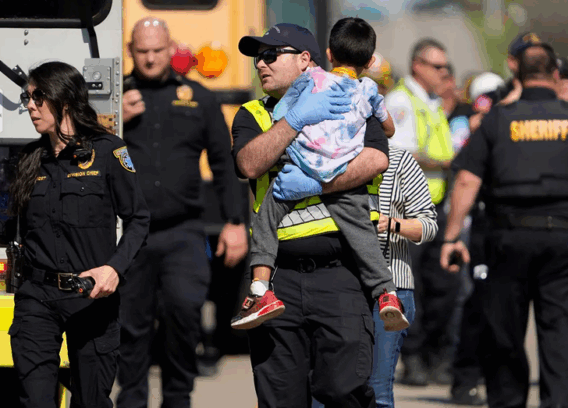 A first responder carries a boy after a school bus crash.