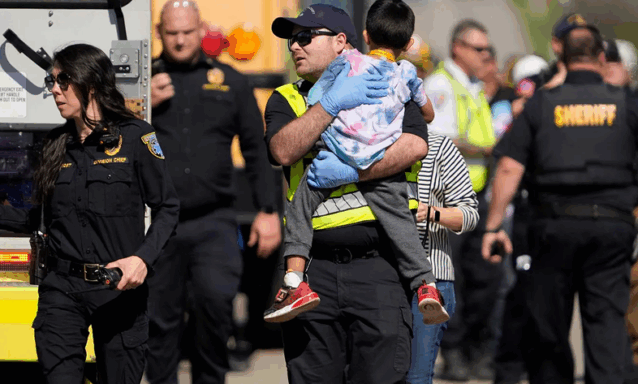 A first responder carries a boy after a school bus crash.