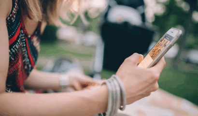 A young woman interacts with her cell phone.