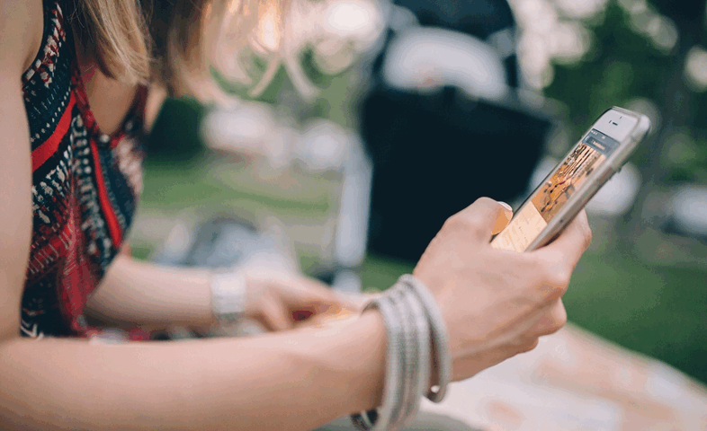 A young woman interacts with her cell phone.