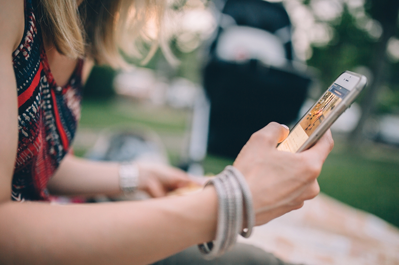 A young woman interacts with her cell phone.