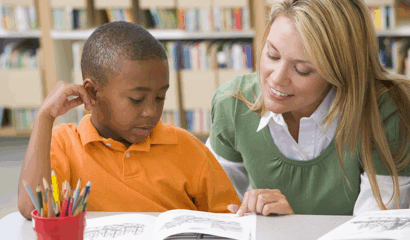 A teacher helps a student with reading.