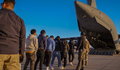 Men stand in line to board a flight.